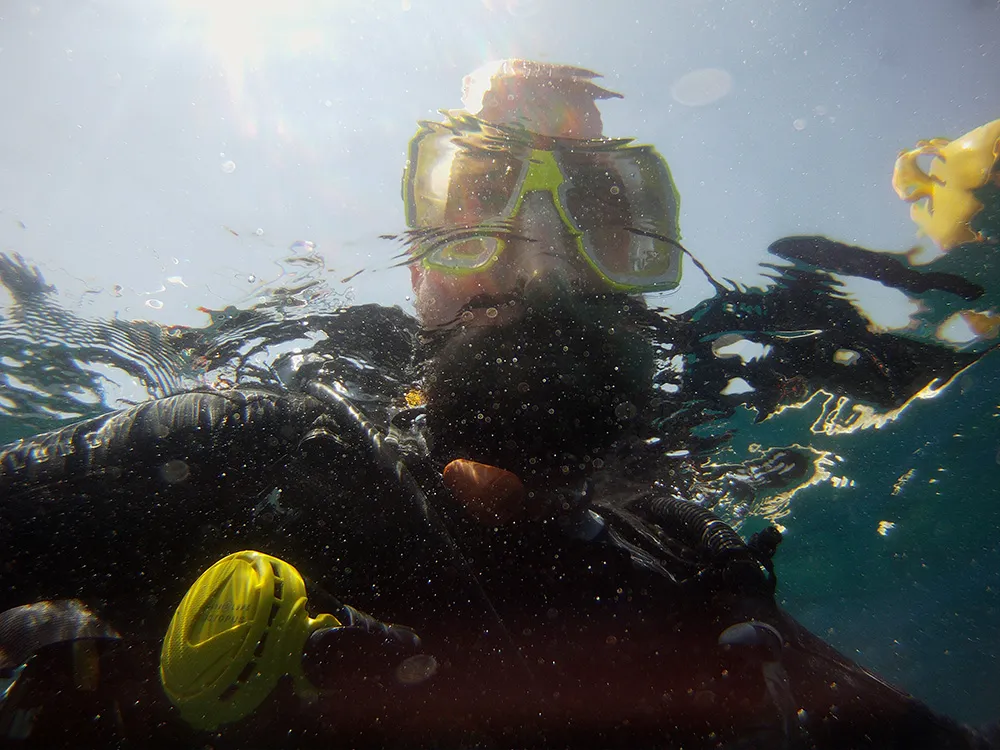 2022 — Unter-Überwasser-Selfie in voller Tauchmontur, kleine Luftbläschen, Unschärfe durch Wellenbewegungen